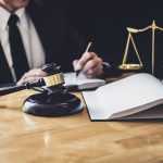 Male Lawyer Or Judge Working With Contract Papers, Law Book And