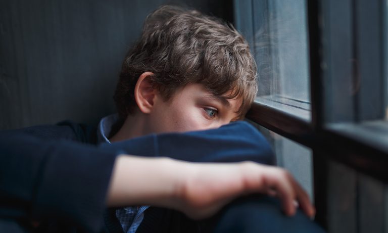 Teenaged Boy Curled Up Wide Eyes Staring Out Window 768