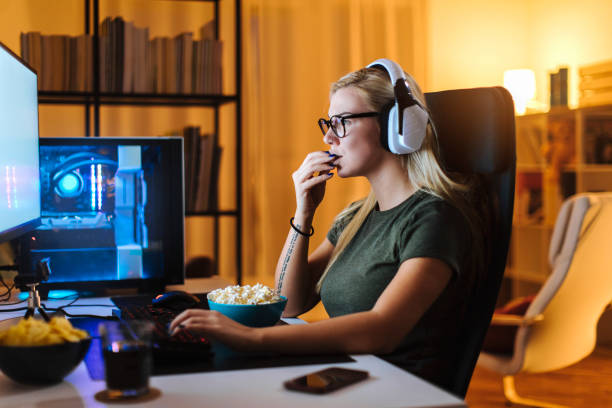 Young Blonde Working On A Computer While Eating Popcorn