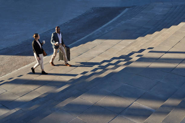 Businesspeople Walking With Bags On Staircase Outside, At Sunrise
