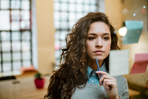 Concentrated Woman Making Plan On Sticky Notes.