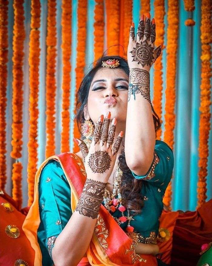 Happy Indian bride at mehndi function. | Indian bride photography poses,  Bride photos poses, Bridal mehendi designs